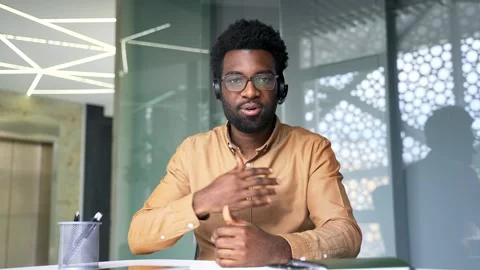 Webcam view of confident African American coach wearing headset looking at camer Stock Footage 337499698