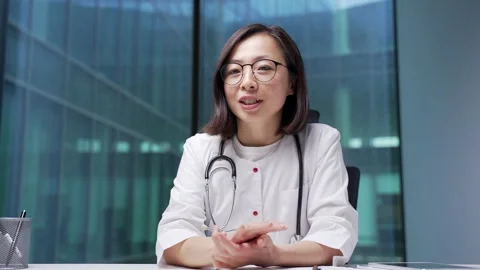 Webcam view. Confident asian female doctor talking on video call online Stock Footage 315464137