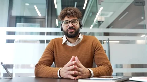Webcam view. Confident businessman in a headset talking on a video call looking  Stock Footage 321820036