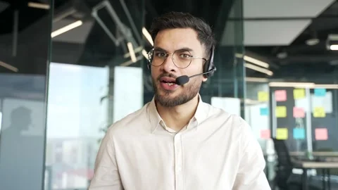 Webcam view. Confident businessman in wireless headset talking on a video call  Video stock 343355917