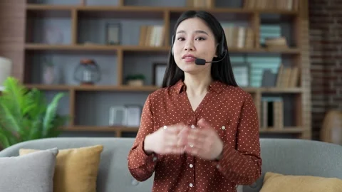 Webcam view. Confident young asian female tutor in headset talking on video call Stock Footage 294689937