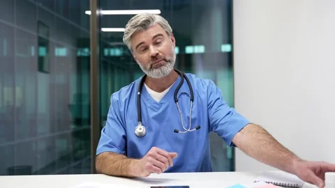 Webcam view Doctor in blue coat talking on video call looking in camera sitting  Stock Footage 325428863
