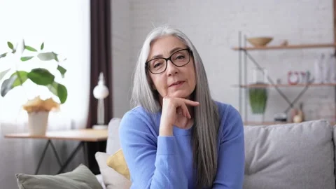 Webcam view. Smiling beautiful elderly gray-haired woman talking to web camera Stock Footage 181508076