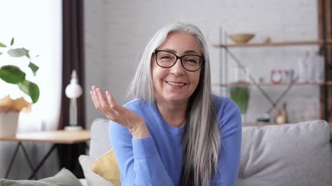 Webcam view. Smiling beautiful elderly gray-haired woman talking to web camera Stock-Footage 213279368