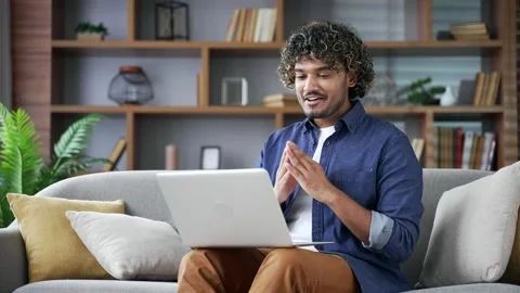 Webcam view. Young man talking on a video call looking at camera sitting on sofa 库存影片 297867473