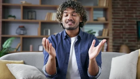 Webcam view. Young man talking on a video call looking at camera sitting on sofa Stock Footage 297868445