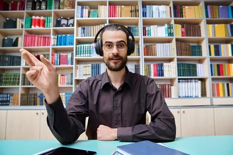 Webcam view young talking man making video call chat conference, in library Stock Photos