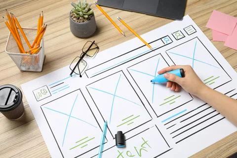 Website designer creating wireframe on paper with highlighter at wooden tab.. 스톡 사진