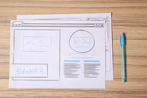 Website development. Sketches of wireframes and pen on wooden table, flat lay 스톡 사진