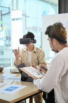 Website development team testing virtual reality headset, brainstorming on Stock Photos