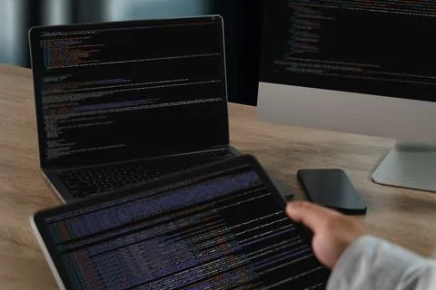 A website programming person working with multiple screens displaying code an 写真素材