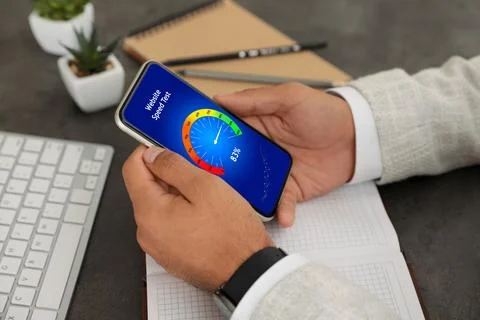 Website speed test. Man using mobile phone at table, closeup Stock Photos