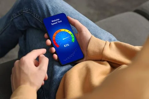 Website speed test. Man using mobile phone at home, closeup Stock Photos