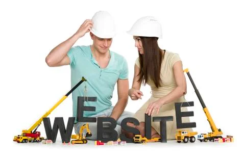 Website under construction: Friendly man and woman building website-word. Stock Photos