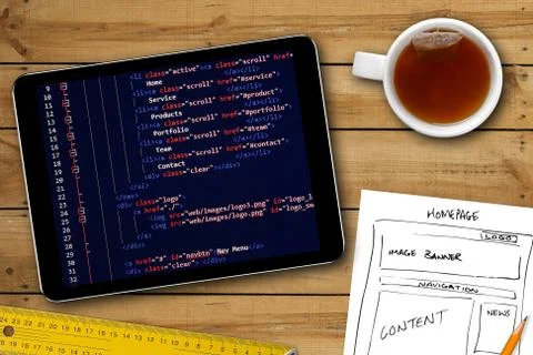 Website wireframe sketch and programming code on digital tablet screen Foto stock