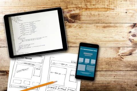 Website wireframe sketch and programming code on digital tablet Foto stock