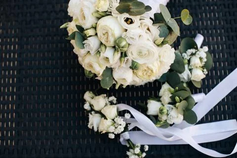 Wedding accessories. White bouquet of the bride and white boutonniere for the Stock Photos