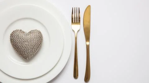 Wedding anniversary dinner table setting, Gold fork and knife on white set of Stock Photos