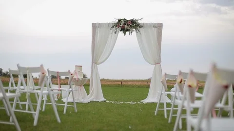 Wedding arch and empty chairs decorated with white and pink flowers Stock Footage 99740294