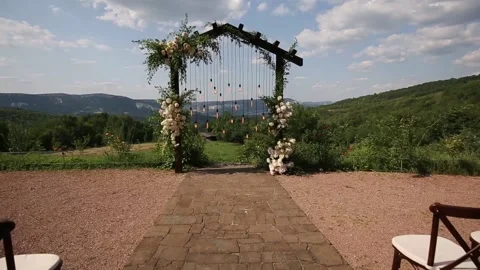 Wedding arch on boho style with white flowers in park with light bulbs. Stock Footage 157888022