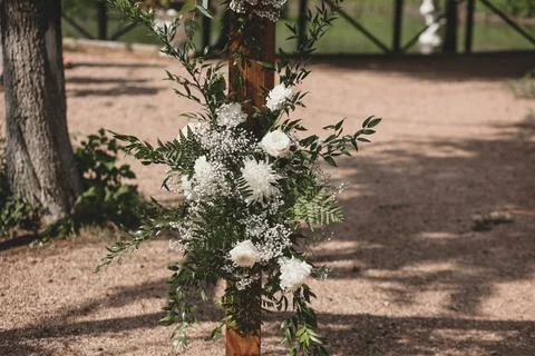 Wedding arch on boho style with white flowers in park. Stock Photos