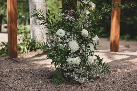 Wedding arch on boho style with white flowers in park. Stock Photos