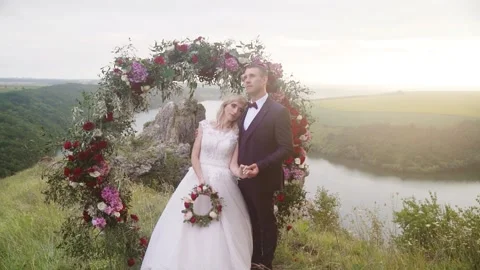 Wedding arch on the edge of a cliff on the background of the river Stock Footage 234086588