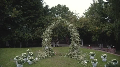 Wedding arch made of white flowers on a green natural background. Stock Footage 256298510