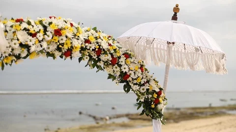 Wedding arch of multi-colored flowers and a ragged umbrella Stock Footage 128564327