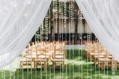 Wedding arch. Preparing for the ceremony in the background wooden chairs Fotos Stock