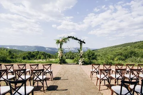 Wedding arch on rustuc style with white flowers in park with light bulbs. Foto stock