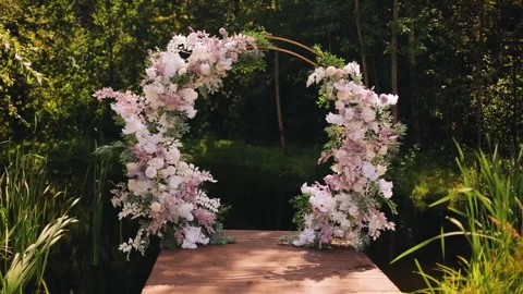The wedding arch stands on a small pier on the shore of the pond Stock Footage 328514069