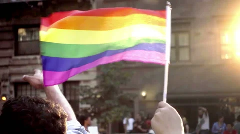 Wedding band on man's ring finger with flags waving in Gay Pride Parade in NYC Stock Footage
