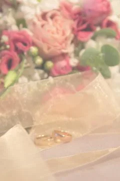 Wedding blurred background: wedding rings with natural roses bouquet vertical Stock Photos