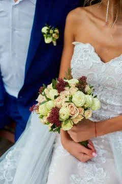 Wedding bouquet holding in a hands of couple. Stock Photos