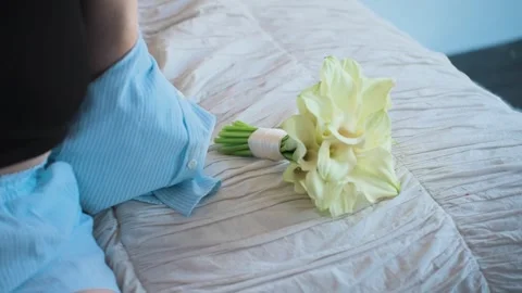 A wedding bouquet on a white bed next to the bride Stockbeeldmateriaal 328048258