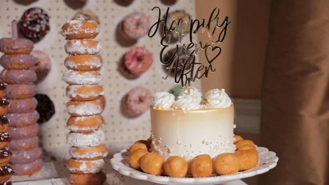 Wedding cake with cake topper and donut wall in background Stock Footage