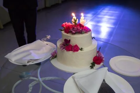 Wedding cake with carnations on a glass table Stock Photos