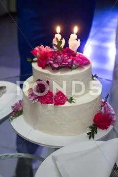 Wedding Cake With Carnations On A Glass Table