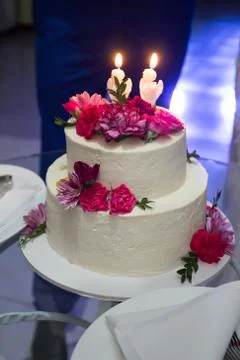 Wedding cake with carnations on a glass table Stock Photos