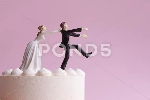 Wedding Cake Figurines, Bride Grabbing Runaway Groom Stock Photos