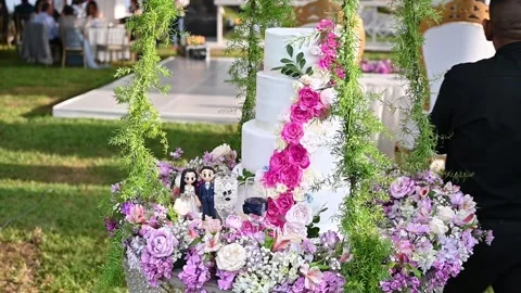Wedding cake hanging from a swing decorated with flowers and figurines Stock Footage 314338217