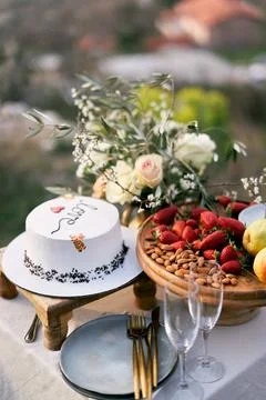 Wedding cake is on the table next to the fruit platter 写真素材