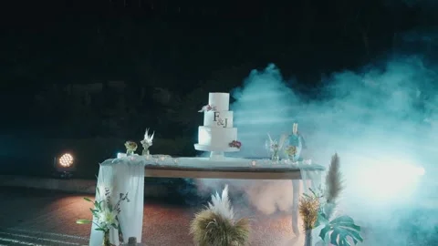 Wedding Cake Table with Smoke Effect and Blue Light at Outdoor Night Reception 動画素材 332920888