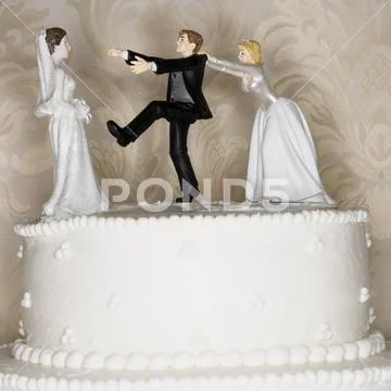 Wedding cake visual metaphor with figurine cake toppers Stock Photos