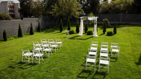 Wedding ceremony. Front low view of the wedding arch in a green field. 库存影片 169482564