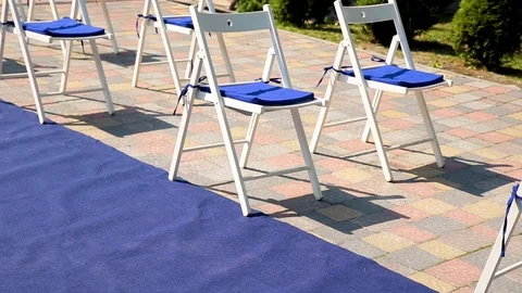 Wedding ceremony outside the restaurant. Chairs and blue walkway for brides and Stock Footage 115706972