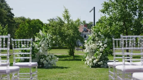 Wedding ceremony setup with floral decorations and chairs in outdoor garden Stock Footage 339581504