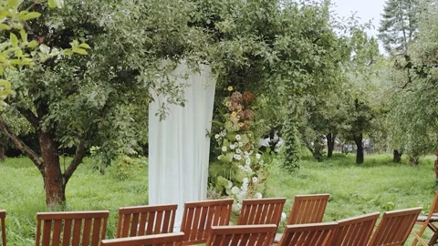 Wedding ceremony setup nestled within a tranquil orchard, adorned with stunning Stock Footage 307425294