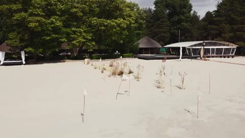Wedding ceremony on a white sandy beach overlooking lush green trees. Aerial Stock Footage 321944448